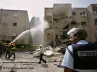 Equipos de salvamento israelíes intentan apagar un incendio en Haifa, provocado por un cohete de Hizbolá. 